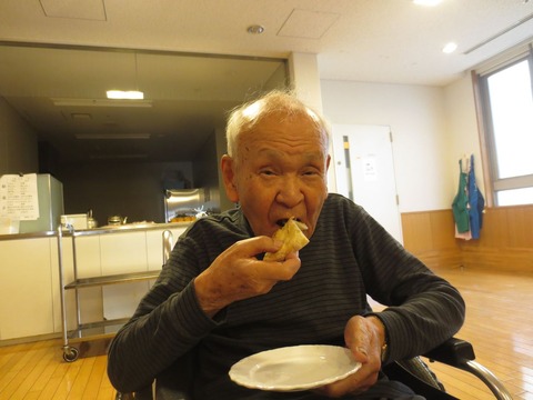 美味しそうにピザを食べるSさん